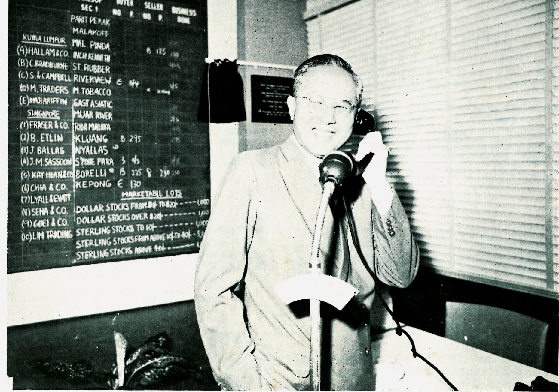 Tan Siew Sin, Malaya Minister for Finance, at the new Kuala Lumpur Trading Room inaugurating the direct telephone line between the Federation and Singapore Trading Rooms, 20 October 1962. Goh Keng Swee was on the other line in Singapore. Reproduced from the 1962 Annual Report of the Malayan Stock Exchange. All rights reserved, Malayan Stock Exchange, 1963.